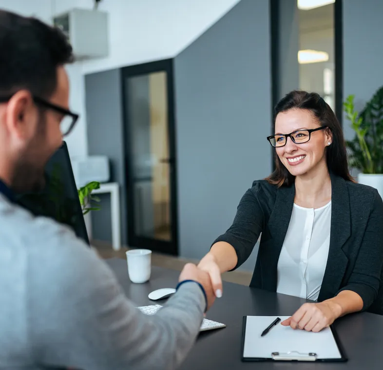 Mujer ejecutiva entrevistando a joven para reclutamiento de agente de seguros